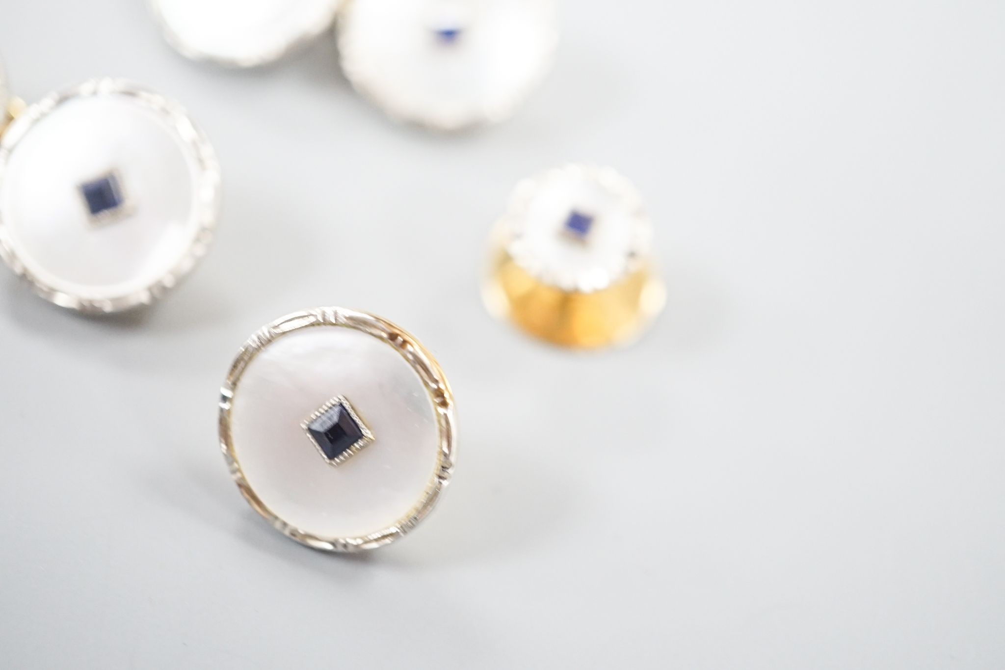 A pair of 18ct, mother of pearl and sapphire set circular cufflinks, 13mm and a pair of matching dress studs, gross weight 8.6 grams.